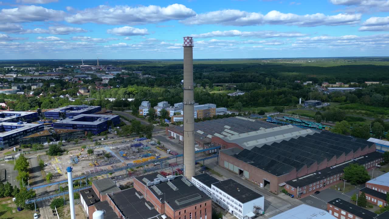 Hennigsdorf steel industry with industrial buildings, chimneys, storage area and a river in the background. Amazing aerial view flight panorama overview drone