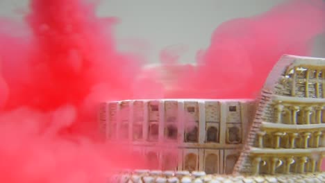 slow motion and close up of colosseum underwater with red water ink swirling around it