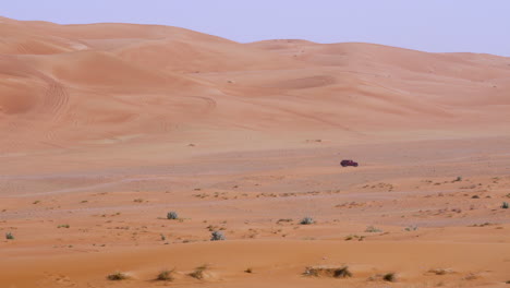 vehicle traveling at remote deserted landscape near fossil rock nature reserve in sharjah, uae