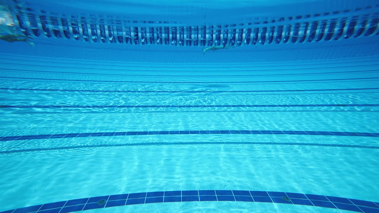 Olympisk svømmebassin under vandbaggrund.