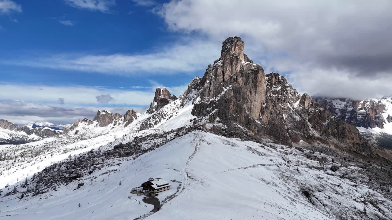 Cinematic drone shot pulling away from Ra Gusela and winter landscape at Passo Giau