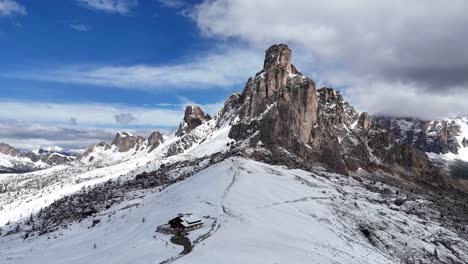 cinematic drone shot pulling away from ra gusela and winter landscape at passo giau