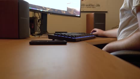 el hombre joven escribe y se desplaza mientras completa un formulario en línea en la computadora de su casa
