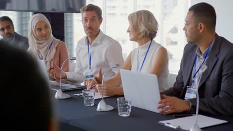 hombre de negocios hablando en un panel de delegados en una conferencia