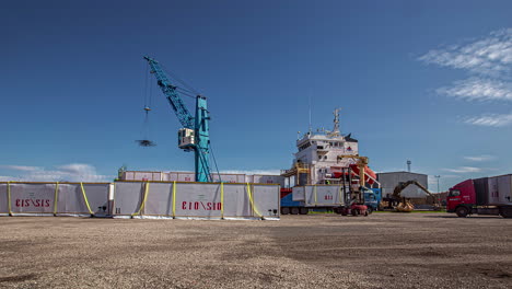 Timelapse-of-large-crane-loading-shipping-containers-onto-barge-for-maritime-export-at-harbor