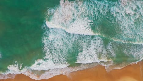 aerial top view blue sea, waves crashing on the beach.