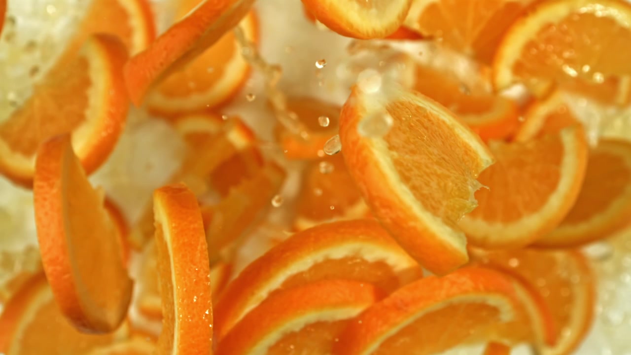 Nahaufnahme von frischen Orangenscheiben, die ins Wasser spritzen