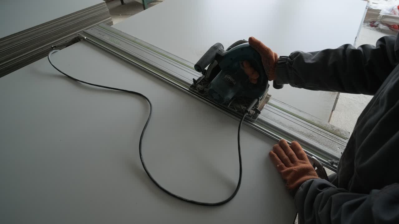 Male hands measuring and cutting gypsum plasterboard