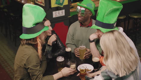 Friends Talking In Pub On St Patricks Day