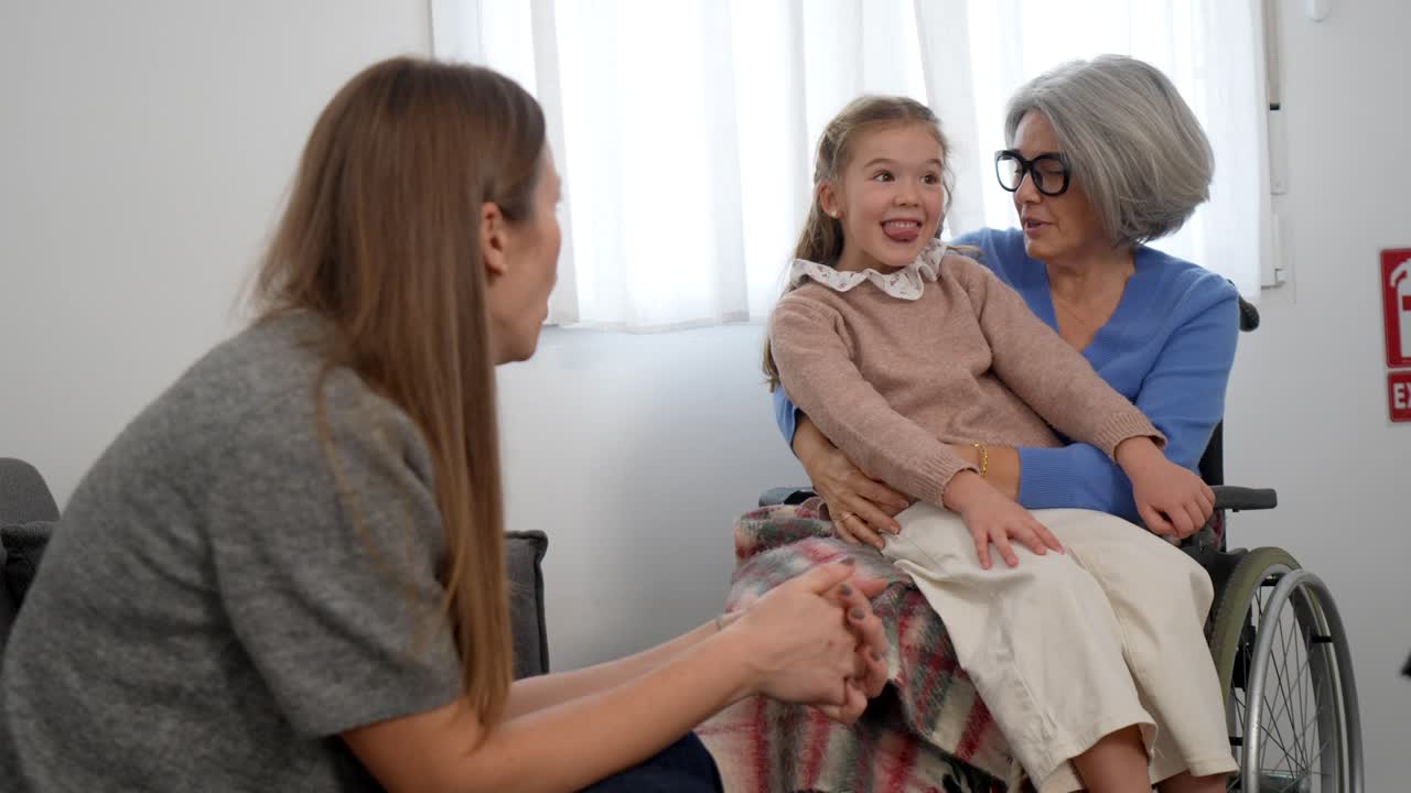 Nonna su sedia a rotelle con nipote e figlia
