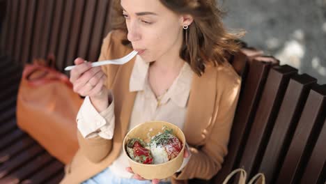 buinesswoman eating healthy takeaway food outdoors