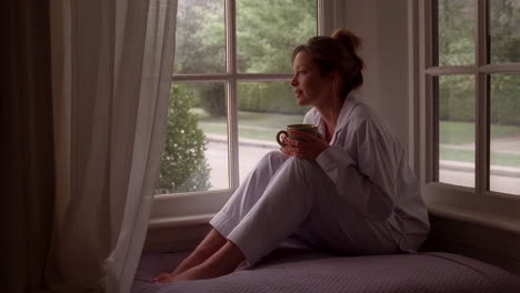 woman relaxing with coffee by the window