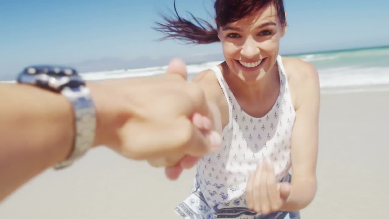 animación de formas coloridas sobre una pareja caucásica en la playa