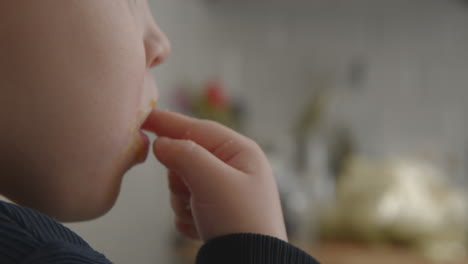 baby girl eating with hands and having messy face