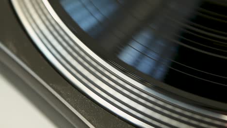 LP-player-starts-playing-music---Close-up-of-spinning-vinyl-record-in-natural-daylight