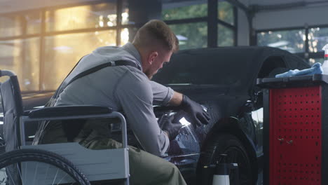 disabled person detailing a car in a garage