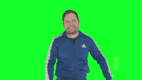 A-handsome-young-man-in-a-tracksuit-runs-fingers-through-his-hair-and-points-at-the-camera,-green-screen