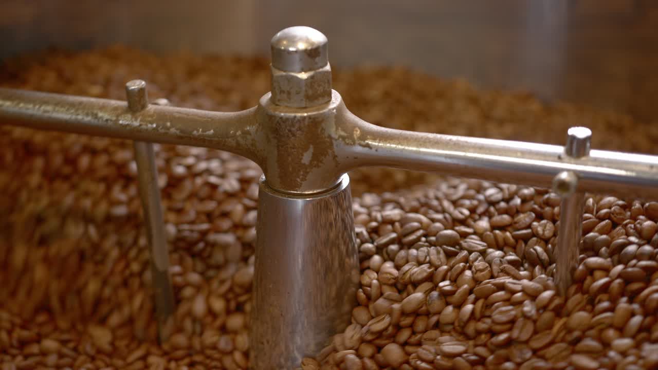 A coffee roaster machine cools freshly roasted coffee beans as they spin within the apparatus