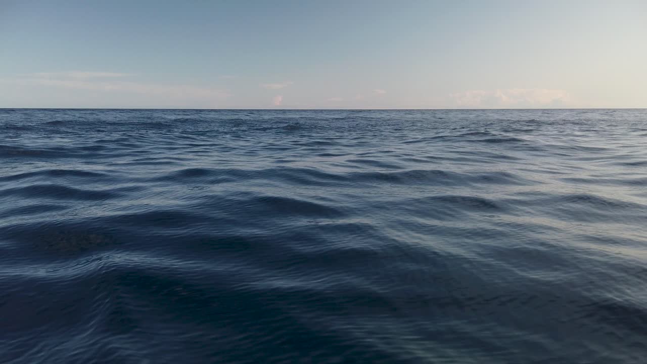 View of calm ocean water surface with small waves and empty horizon, slow motion
