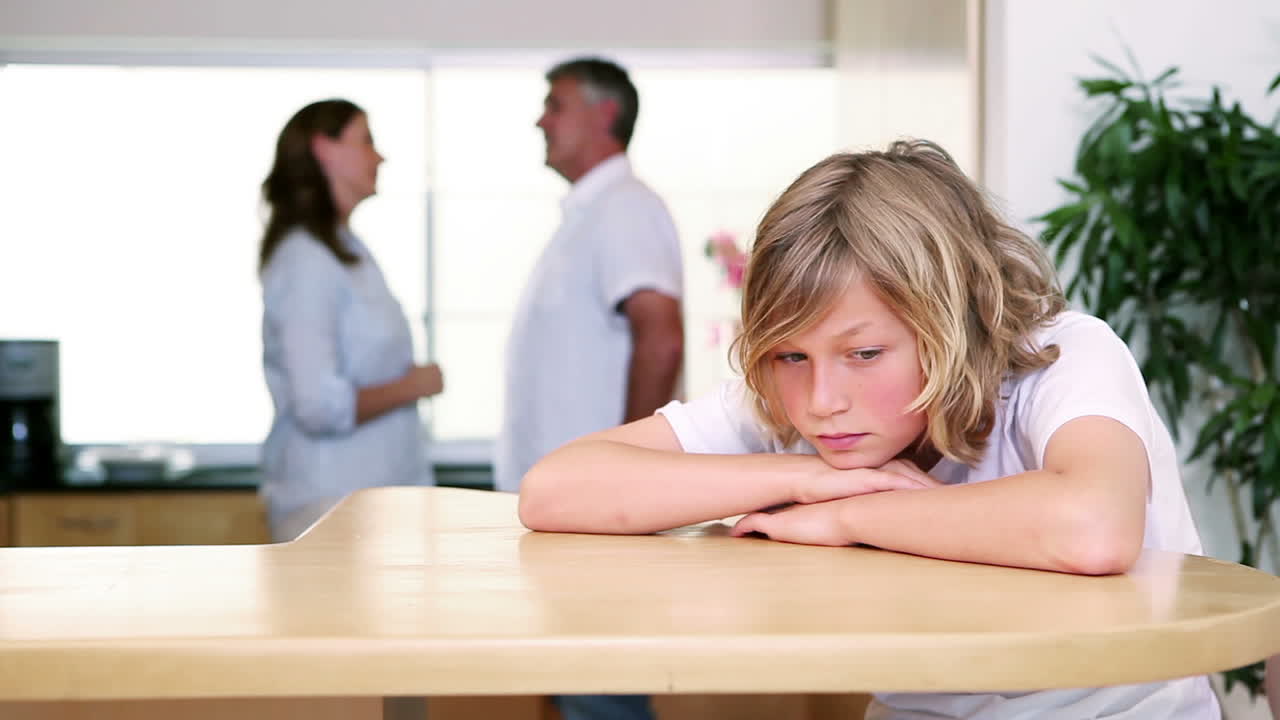 Bambino triste che ascolta i suoi genitori litigare