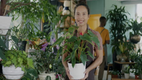 woman florist holding a plant in a shop
