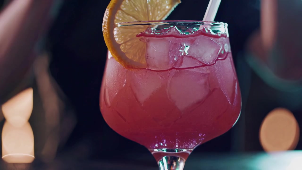 Líquido rojo vertido en un cóctel refrescante con hielo y limón