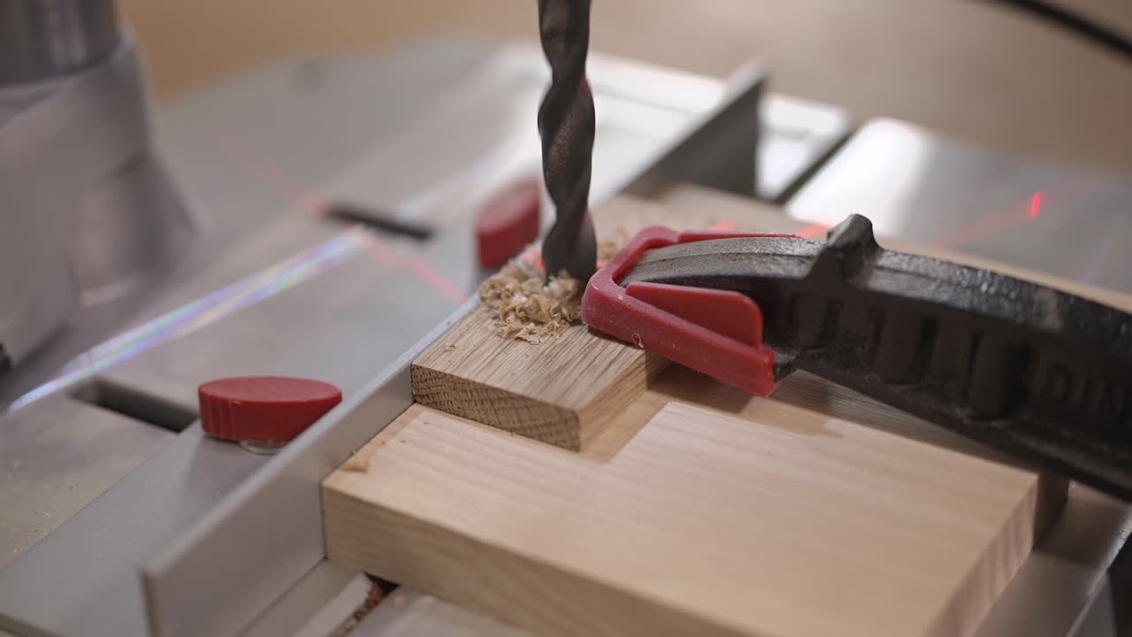 Close up video of drilling a wooden piece secured with a clamp on a workbench. Precision woodworking process, tool accuracy, DIY carpentry and safe workshop practice