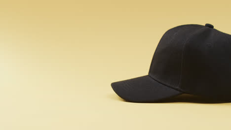 video of black baseball cap and copy space on yellow background