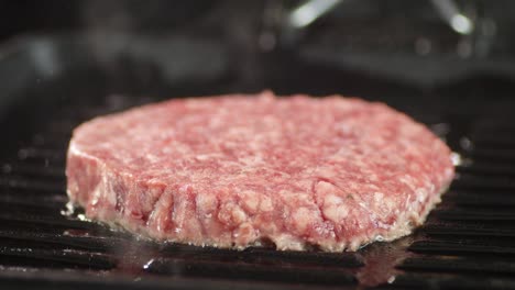 raw beef burger is fried with hot steam.