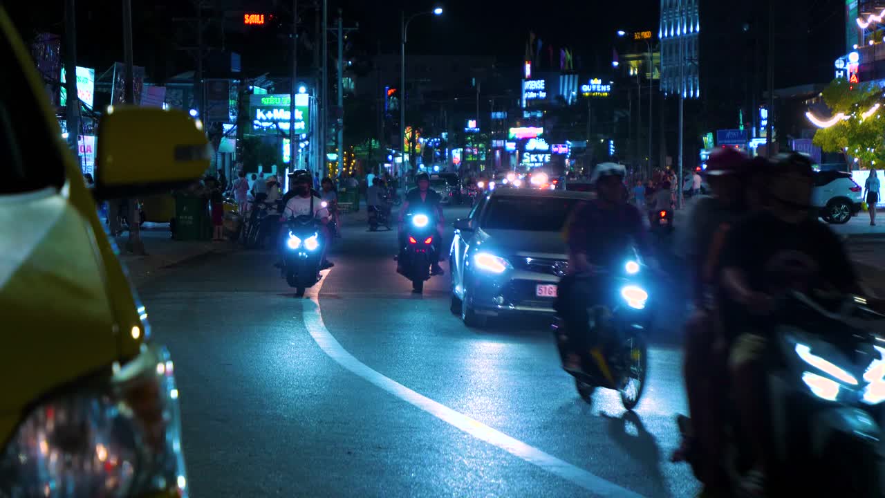 Experience the lively atmosphere of Phu Quoc Island as local people cruise through a bustling tourist road at night
