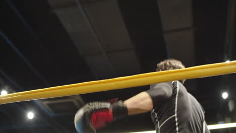 Sleepy-male-boxer-making-break-at-gym.-Sport-man-returning-on-boxing-ring