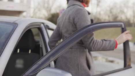 closeup view of business woman in grey coat getting out of car