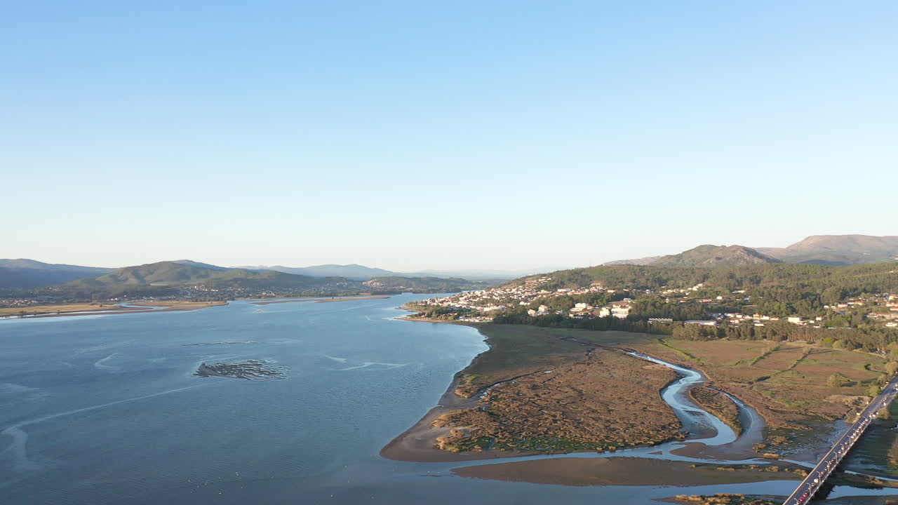 toma aérea de gran angular, panorámica a través del estuario del río minho, con vistas a un puente en caminha, portugal