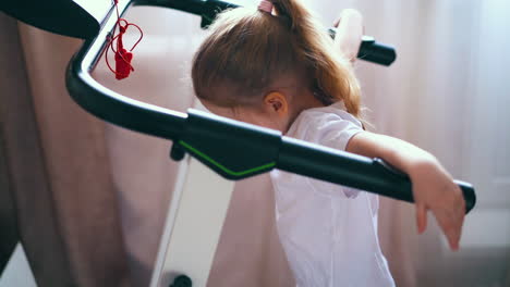 pretty girl in white t-shirt works with treadmill in room