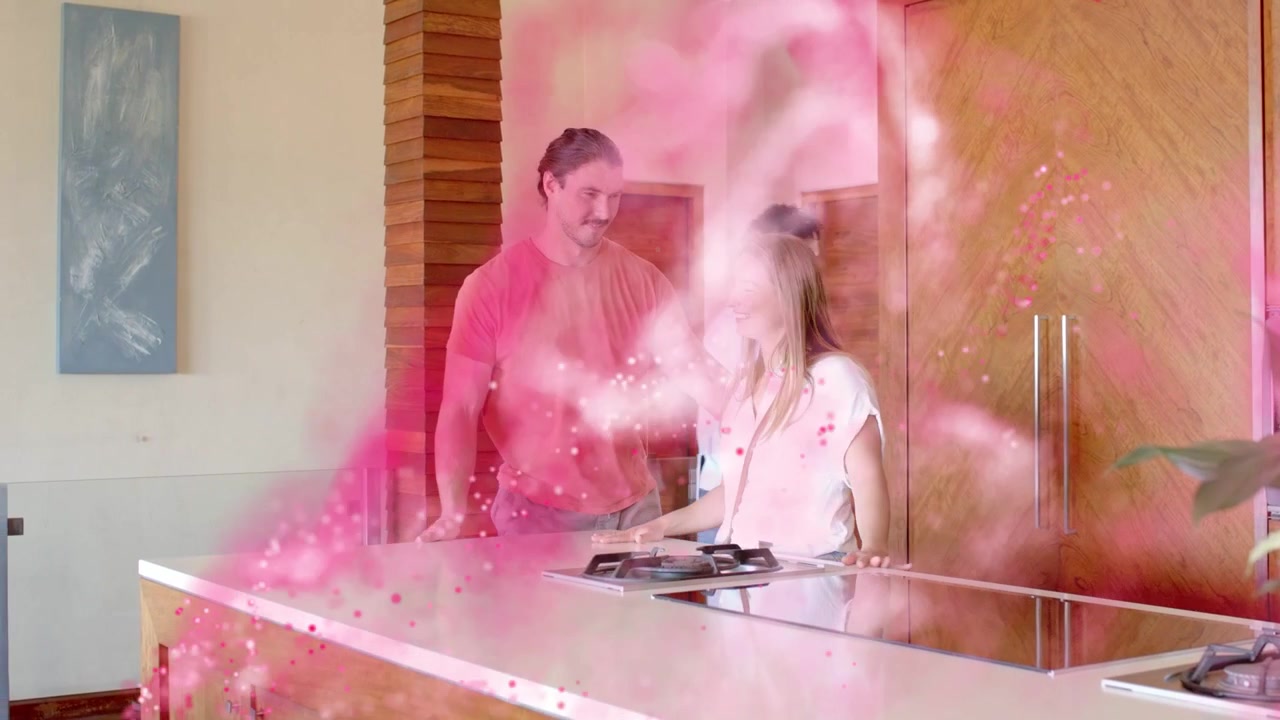 Uomo che tocca il tablet mostrando un piatto, glielo porge mentre lei lo osserva, sorridendo, con un vortice rosa in cucina che si diffonde.