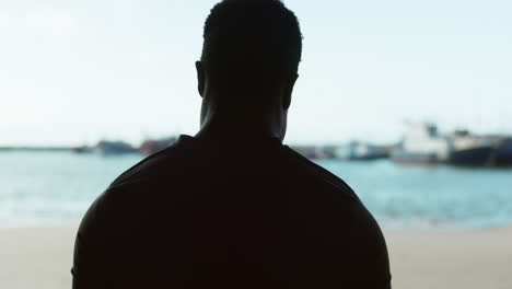 man, stretching back and shoulder in silhouette