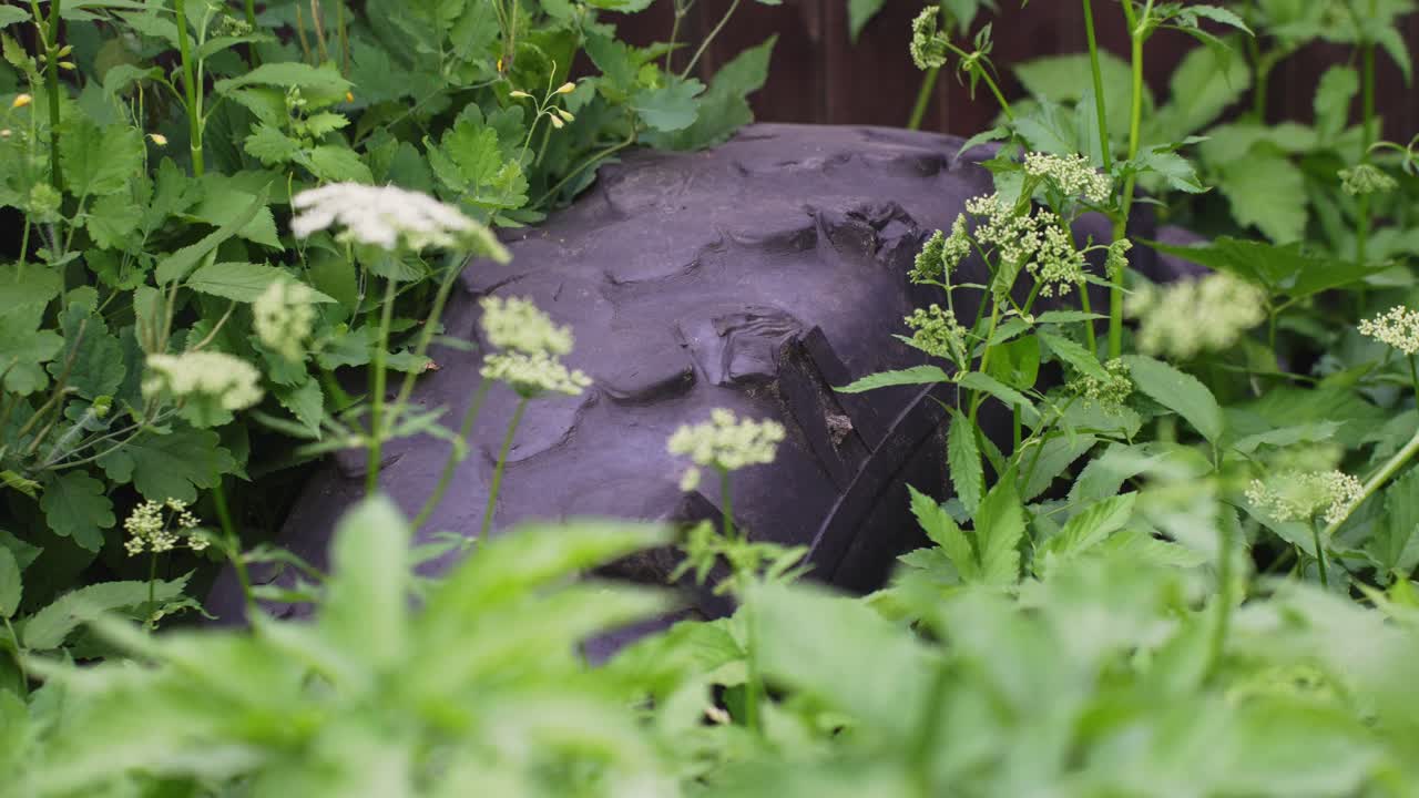 풀밭에 버려진 오래된 트랙터 타이어