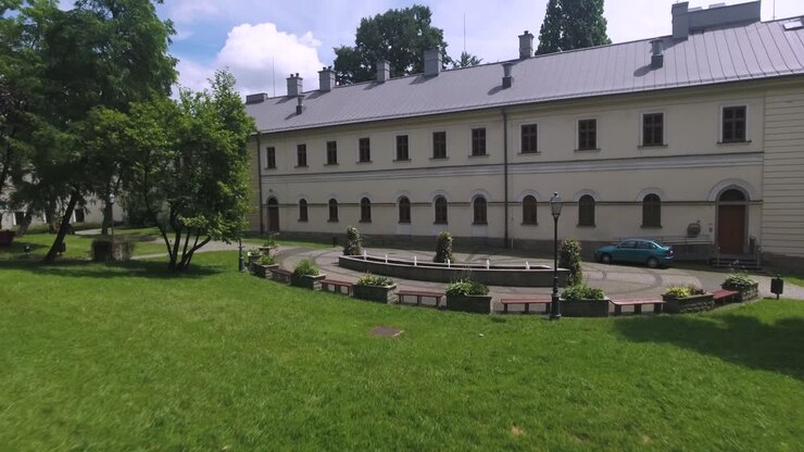 Un palazzo ristrutturato con una fontana e aiuole in Europa durante la stagione estiva