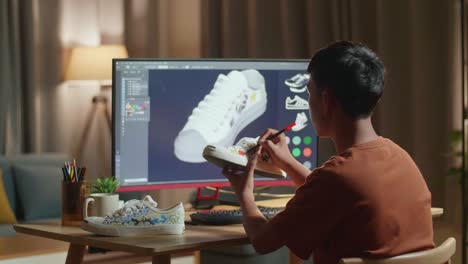 persona que diseña zapatillas personalizadas en una computadora