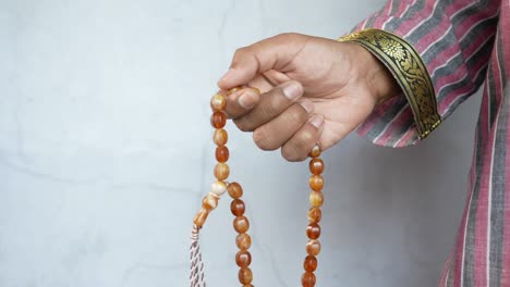 muslim man keep hand in praying gestures during ramadan, close up