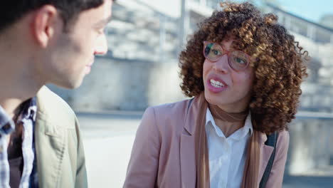 young businesswoman talking with coworker outdoors