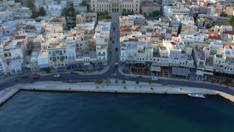 aéreo: toma panorámica lenta de un dron del puerto de siros y el ayuntamiento durante la puesta de sol