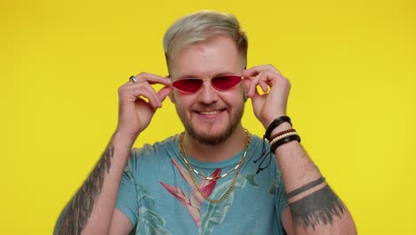 playful happy man wearing sunglasses blinking eye looking at camera with smile, winking, flirting