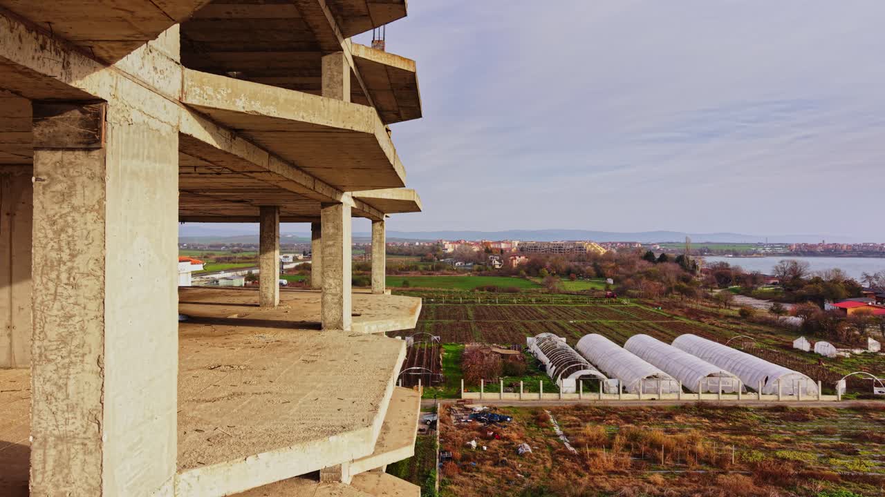 Aerial view of unfinished building near farms and lake