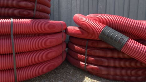 close up: hot sunbeams shine on stacks of sewage tubing near construction site