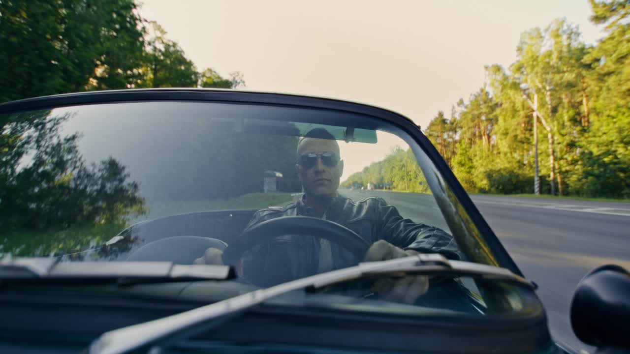 Man Driving Convertible on Road