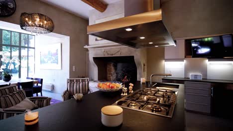 slow orbiting shot of an open plan kitchen with breakfast bar and fireplace in a castle