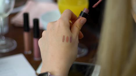 High-Definition-Aufnahme-Eines-Mädchens,-Das-Bei-Einem-Beauty-Event-Lippenstift-Auf-Der-Hand-Testet