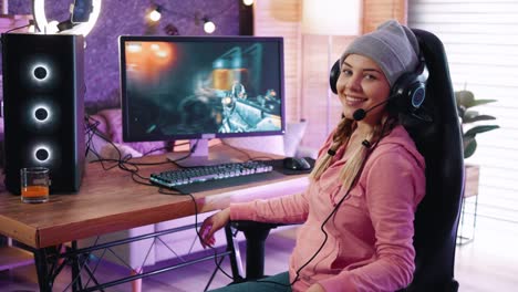 retrato de una joven streamer mirando a la cámara después de jugar un juego de disparos en casa