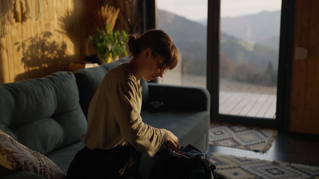 Woman packing backpack indoors